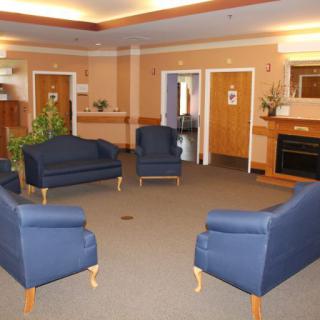 A cozy lobby featuring blue chairs arranged in a circle, creating a welcoming seating area.