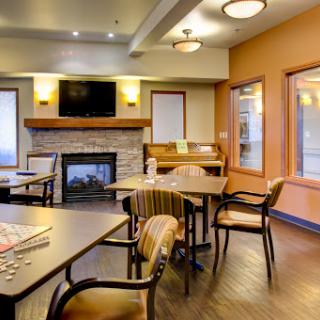 A cozy lounge area featuring comfortable seating, a fireplace, and a television.