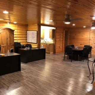 A modern office space featuring wooden walls, sleek furniture, and ample lighting.