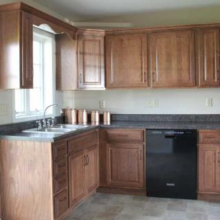 A modern kitchen with wooden cabinets and a black dishwasher.