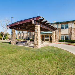 A modern building with a covered outdoor entrance and well-maintained lawn.
