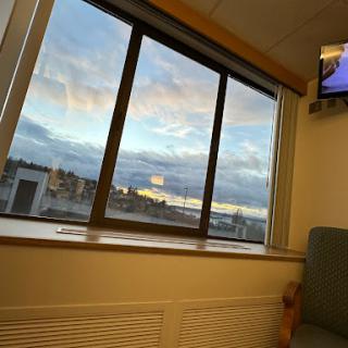 A view from inside a room, showcasing clouds and a hint of sunset through the window.