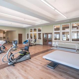 A well-equipped fitness center featuring various exercise machines and a spacious training area.