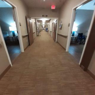 A well-lit hallway with open doors on either side.
