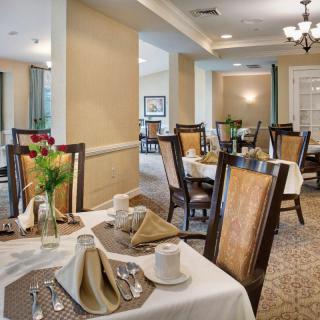 A formal dining room with neatly set tables and elegant decor.