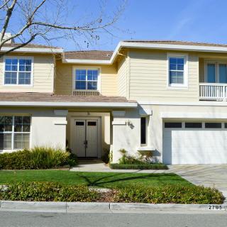 A two-story suburban house with a garage and landscaped front yard.