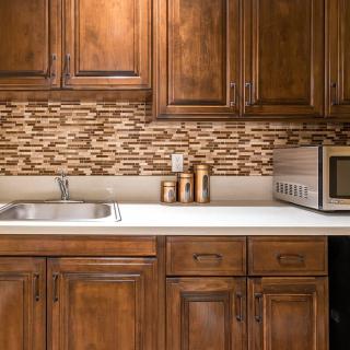A cozy kitchen with wooden cabinets and a modern backsplash.