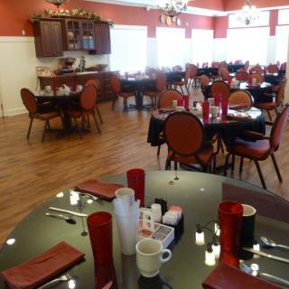 An empty restaurant dining area with neatly set tables and chairs.