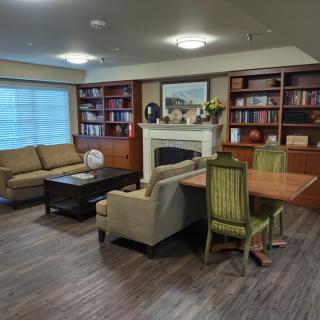 A cozy living room with sofas, a fireplace, and bookshelves.