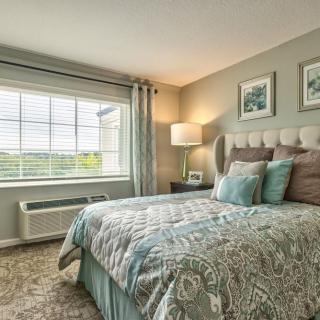 A cozy and well-decorated bedroom with natural light streaming through the window.