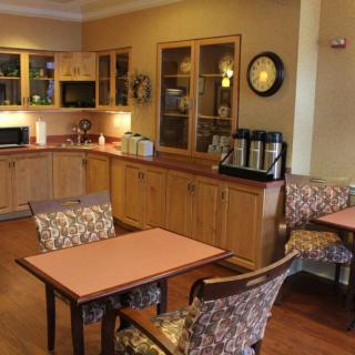 A cozy kitchen and dining area with wooden cabinets and a coffee station.