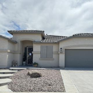 A modern residential home with a landscaped front yard and a garage.