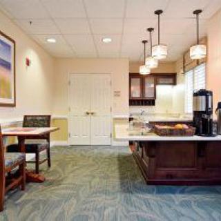 A cozy dining area with a kitchen counter and coffee machine, featuring warm lighting and comfortable seating.