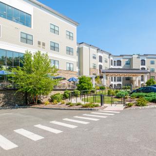 A modern residential building with landscaped gardens and a welcoming entrance.