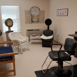 A cozy hair salon with chairs, mirrors, and hairdryers.