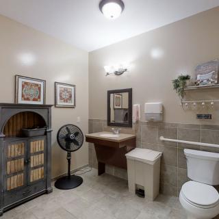 A well-decorated bathroom with a vintage cabinet, wall artwork, and essential amenities.