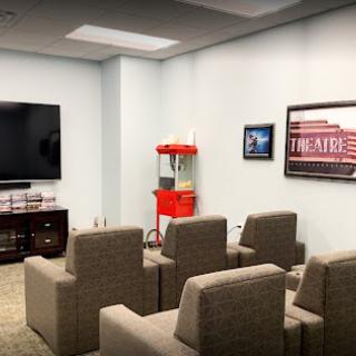 A cozy home theater setup with comfortable seating and a popcorn machine.