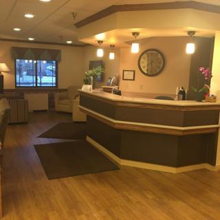 A warmly lit reception area with a wooden desk and seating arrangement.