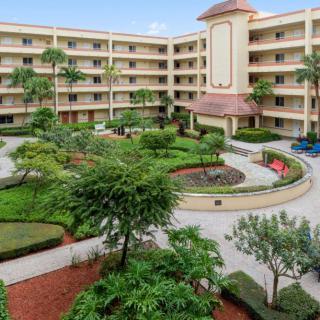 A well-maintained hotel courtyard surrounded by lush greenery and a multi-story building.