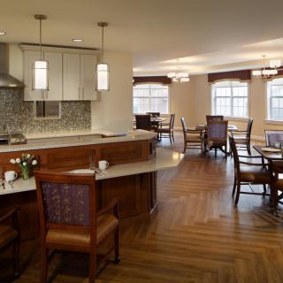 A modern kitchen and dining area with wooden flooring and elegant furniture.