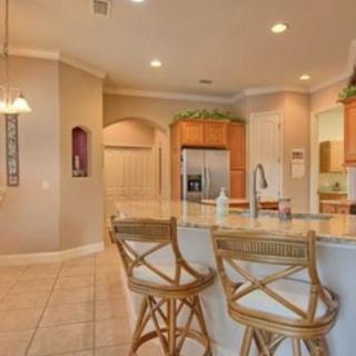 A modern kitchen with bar stools and a spacious open layout.