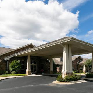 A welcoming entrance to a hospitality building under a partly cloudy sky.