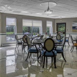 A spacious and well-lit dining room with neatly arranged tables and chairs.