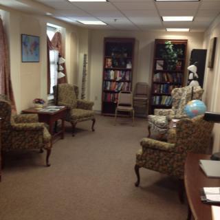 A cozy library reading room with armchairs and bookshelves.