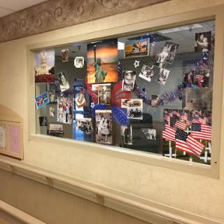 A colorful collage of photographs and flags displayed in a hospital hallway.