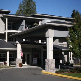 A modern building with a prominent entrance and surrounding trees.