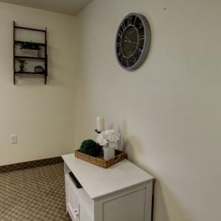 A cozy interior corner featuring a small white table with decorative items and wall art.