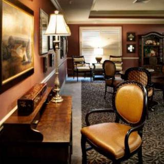 A warmly lit classic interior features elegant furniture and artwork on the walls.