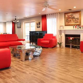 A modern living room with vibrant red furniture and a cozy fireplace.