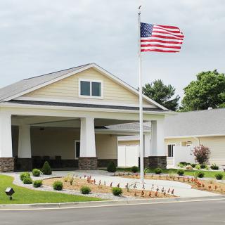 A suburban building with an American flag flying outside and well-maintained landscaping.