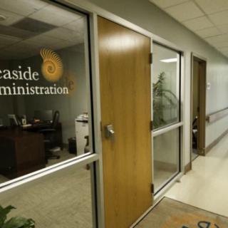A hallway leading to an office with a glass door labeled 'Administration'.