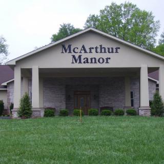 The entrance of McArthur Manor with a prominent sign and a well-maintained lawn.