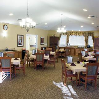 A well-lit dining room with neatly arranged tables and chairs.