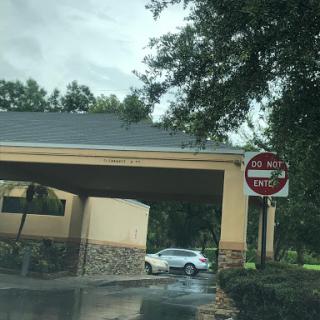 A view of a building entrance with a 'No Entry' sign and a parked car.