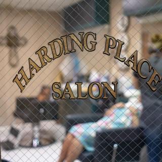 The view through the window shows a cozy salon interior with chairs and hairdressing equipment.