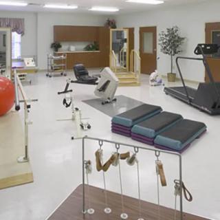 A well-equipped rehabilitation gym with various exercise machines and therapy tools.