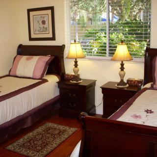 A cozy bedroom with two twin beds and warm lighting from table lamps.
