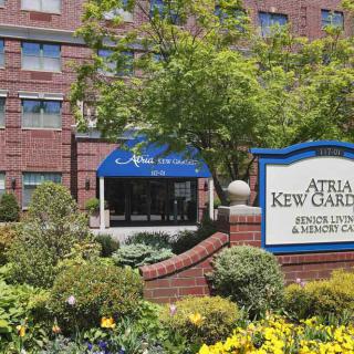 Entrance of Atria Kew Gardens, featuring well-maintained landscaping and signage.