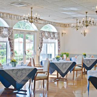 Elegant dining room with chandeliers and large windows.