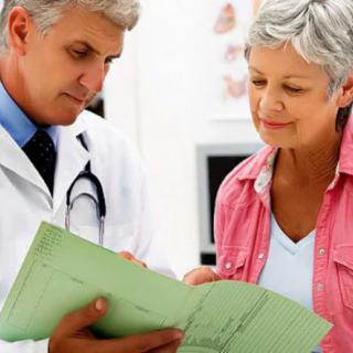 A doctor consulting with a patient, reviewing medical documents together.