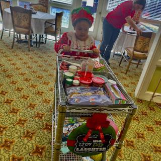 A child joyfully pushes a cart filled with holiday treats and decorations.