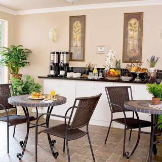 A cozy dining area featuring a breakfast buffet with modern decor and indoor plants.