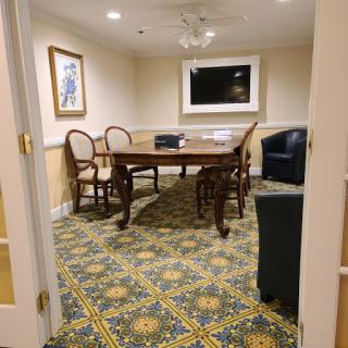 A cozy meeting room featuring a wooden table, chairs, and a television.
