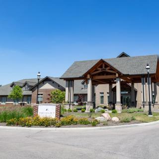 A modern residential building with a well-maintained landscape and clear blue sky.