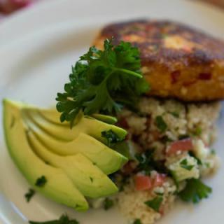 A gourmet vegetarian dish featuring sliced avocado and quinoa salad.