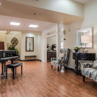 A cozy lounge area with a piano and comfortable seating.